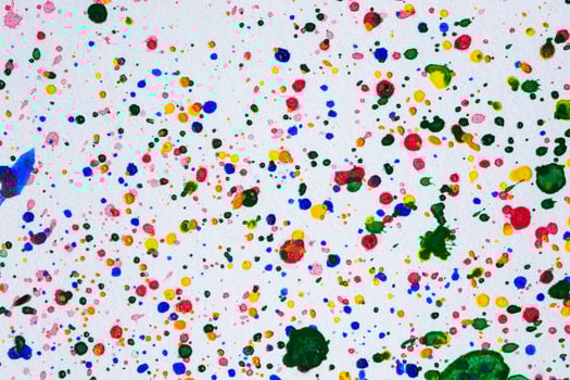 A white wall with many colorful paint splatters photo