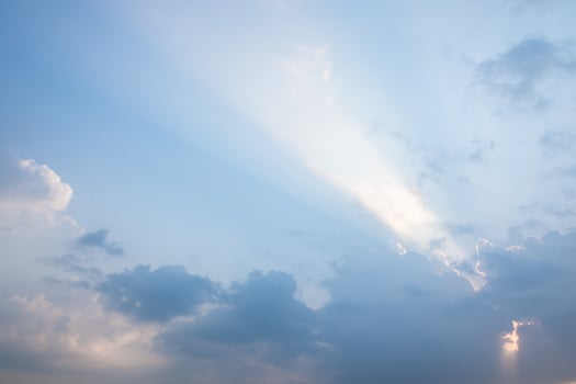 A large cloud with sun rays shining through it photo