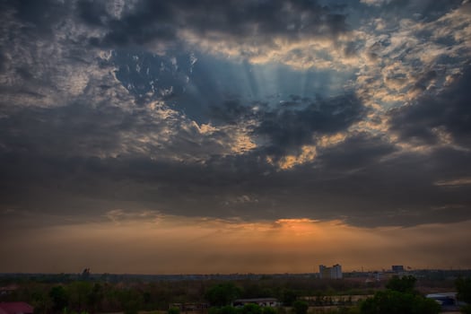 A beautiful sunset over a city with clouds photo