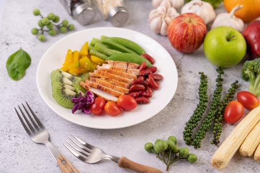 Chicken steak with peas, tomatoes, kiwi and pumpkin. photo