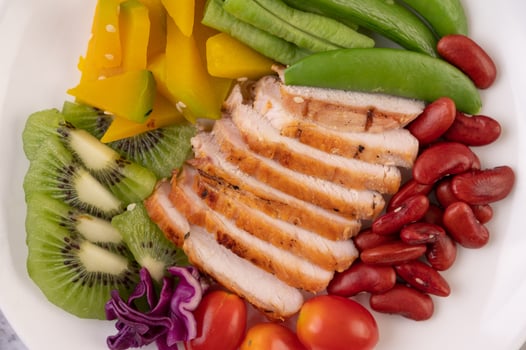 Chicken steak with peas, tomatoes, kiwi and pumpkin. photo