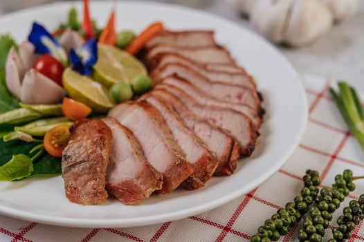 Pork with lemon, onion, red onion, tomato, long bean, butterfly pea flower, and mint. photo
