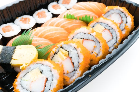 A black container with sushi rolls and other food photo