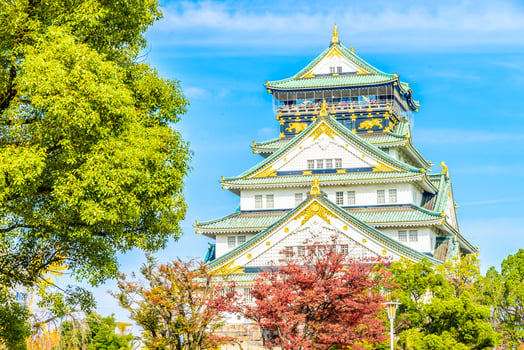 The osaka castle is a beautiful building with a lot of gold and green photo