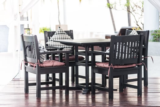 A wooden table and four chairs on a wooden deck photo