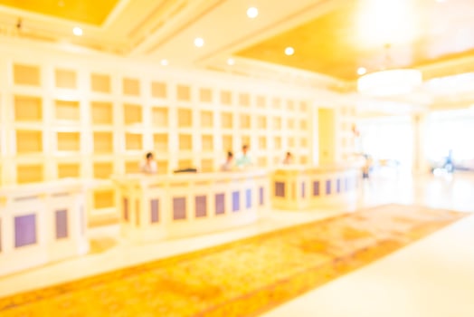 A blurry image of a hotel lobby with people at the front desk photo