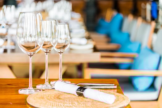 A table with wine glasses and place settings photo