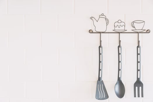 A kitchen utensil rack with three spoons and a fork photo
