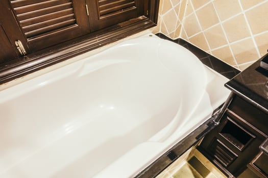 A bath tub sitting next to a sink in a bathroom photo