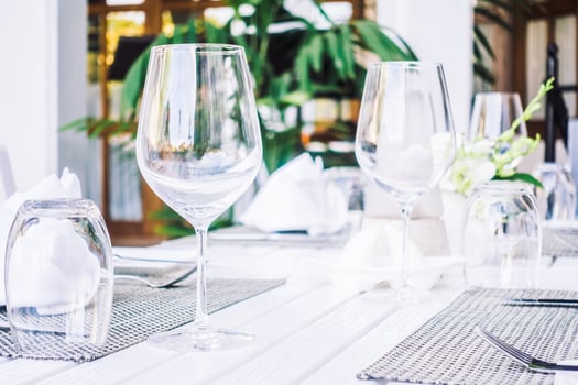 A table with empty wine glasses and place settings photo