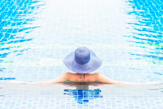 A woman in a blue hat sitting in a pool photo