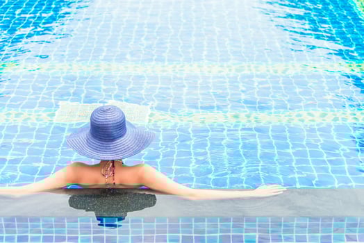 A woman in a blue hat sitting in a pool photo
