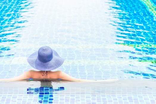 A woman in a blue hat sitting in a pool photo