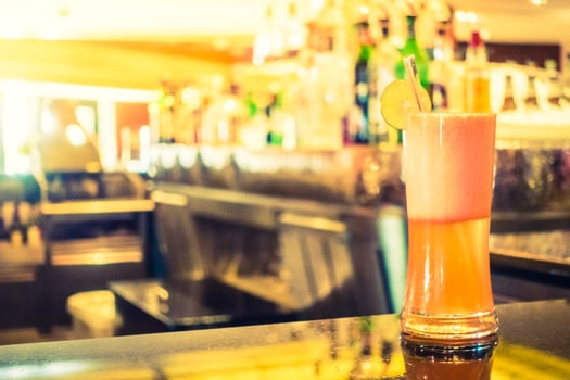 A pink drink sitting on a bar counter photo