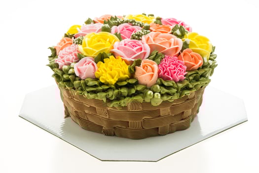 A cake with a basket of flowers on a white plate photo