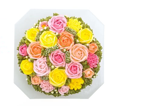 A cake with colorful flowers on a white surface photo