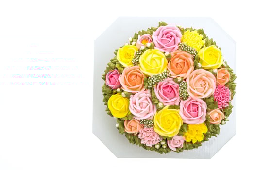 A cake with colorful roses on top of a white box photo