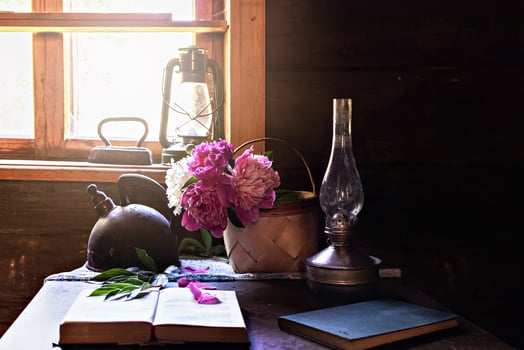 Still life of vintage items and a bouquet of peonies on a table by the window in an old village house. photo
