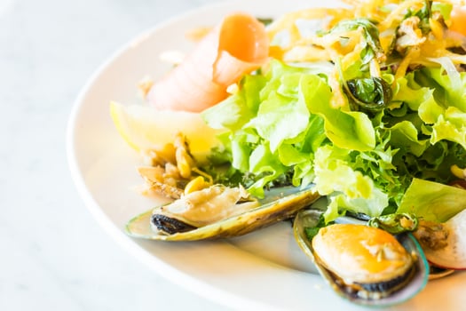 A plate of food with a salad and mussels photo