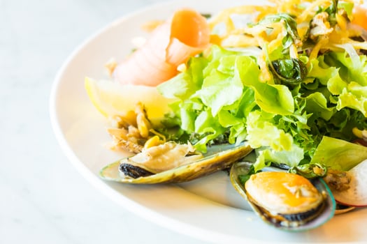 A plate of food with a salad and mussels photo