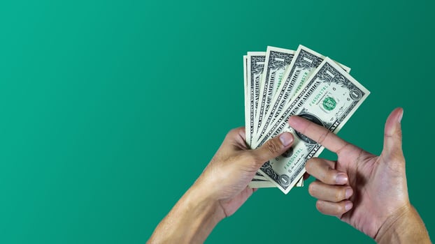 Hand holding dollar design on green background photo