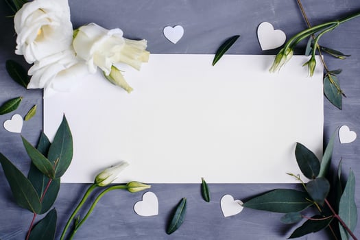 Blank paper copy space. Frame with flowers. Silk ribbon. Gray background. Simple bouquet. Greeting card. photo