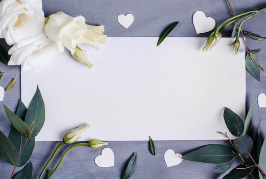Blank paper copy space. Frame with flowers. Silk ribbon. Gray background. Simple bouquet. Greeting card. photo