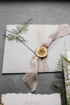 Wedding details flat lay. Wedding invitation and scroll paper. Bottle with fragrance. Ring box. Simple bouquet. photo