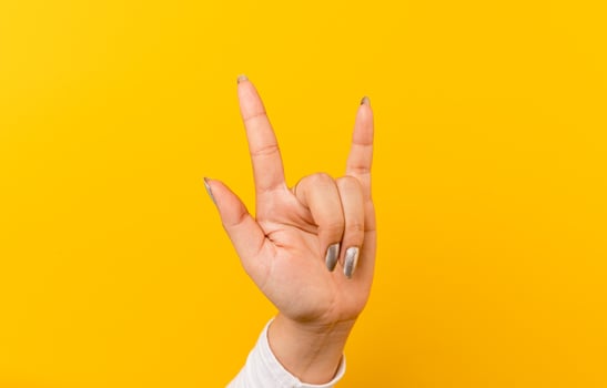 hand expressing love An image of an Asian woman showing her hands showing love. on a yellow background photo