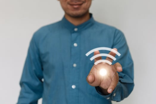 Young handsome wearing a light blue shirt turn on wifi and connected to Wi-Fi technology for using smart home function. Technology business and modern lifestyle concept. photo