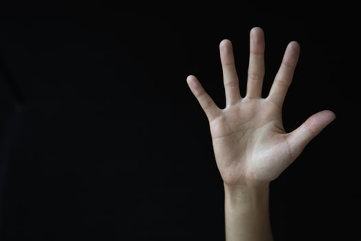 Woman's palm on black background. Abused woman. Stop violence and abuse of women. International Women's Day. photo