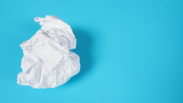 Crumpled white paper.It is mauled on sky blue background. photo
