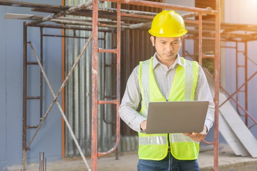 A male engineer looks at the floor plan at the construction site. photo