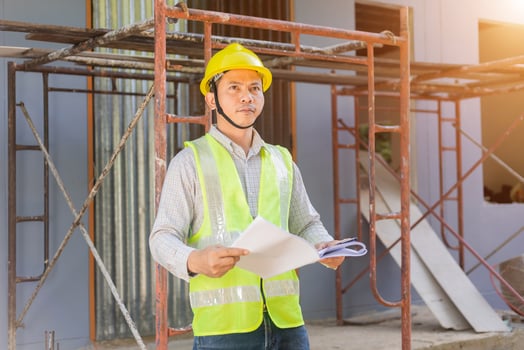 A male engineer looks at the floor plan at the construction site. photo