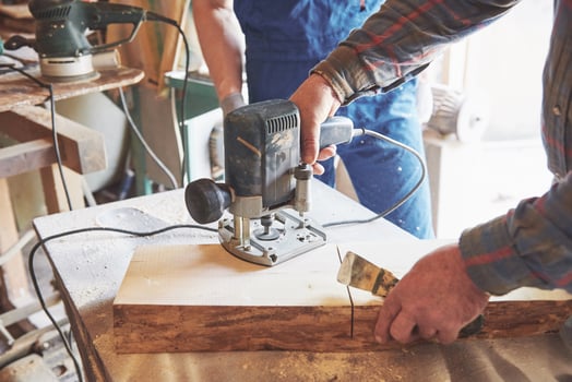 Portrait of a carpenter in working clothes in the workshop of the joiner's shop. photo