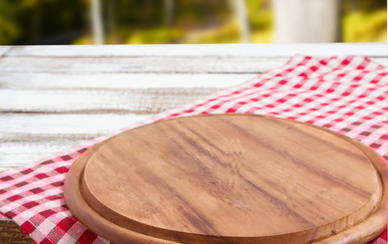 Napkin and board for pizza on wooden desk closeup, tablecloth. Canvas, dish towels on white wooden table background top view mock up. Selective focus photo