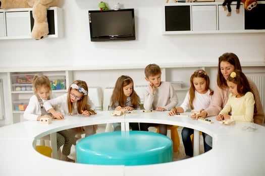 Group of cute little kids playing with preschool educational toys with kindergarden teacher photo