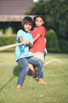 Children group playing tug of war at the park photo