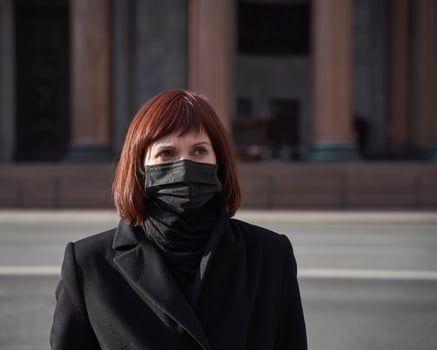 A sad woman with mask on her face stands near closed Museum. Ban on walking, visiting public places photo