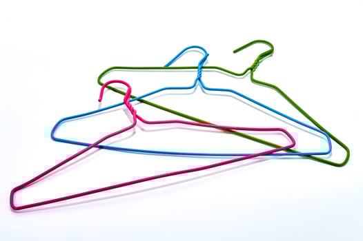 Pink blue and green hangers on a white background. photo