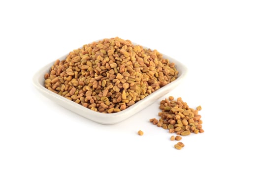 Fenugreek seeds in white plate isolated on white background photo