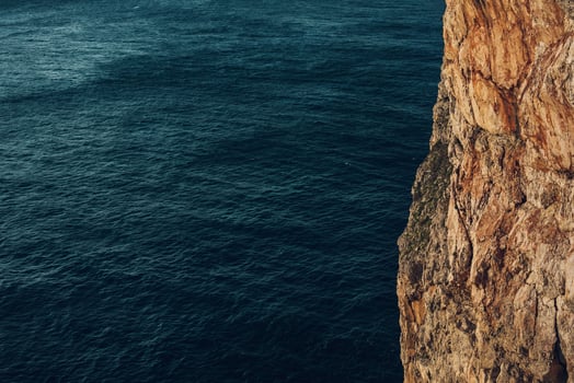 a view of a rock in the sea photo
