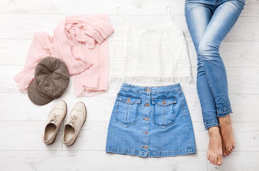 Casual summer outfit with different accessories and female legs in jeans on white wooden floor. Top view and copy space. photo