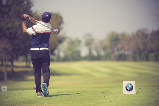Golfers hit sweeping golf course in the summer.Vintage color photo