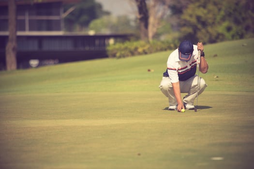 Pro golf player aiming shot with club on course.golfer on putting green about to take the shot photo