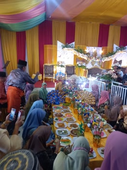 Medan, Indonesia January 23, 2022 In a North Sumatran Malay traditional wedding, there is a traditional ceremony of eating rice in front of the bride and her family photo