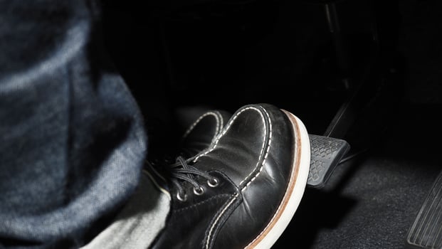 Accelerate and Brake. Foot pressing foot pedal of a car to drive ahead. photo