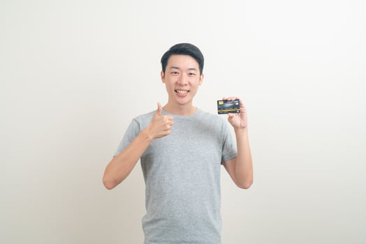 young Asian man holding credit card photo