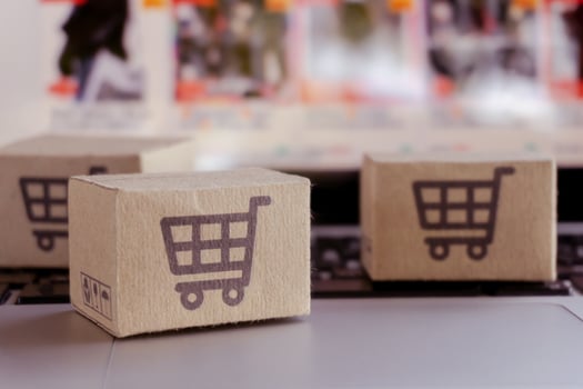 Online shopping. Cardboard box with a shopping cart logo on laptop keyboard. Shopping service on The online web. offers home delivery photo