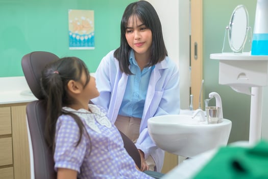 A little cute girl having teeth examined by dentist in dental clinic, teeth check-up and Healthy teeth concept photo